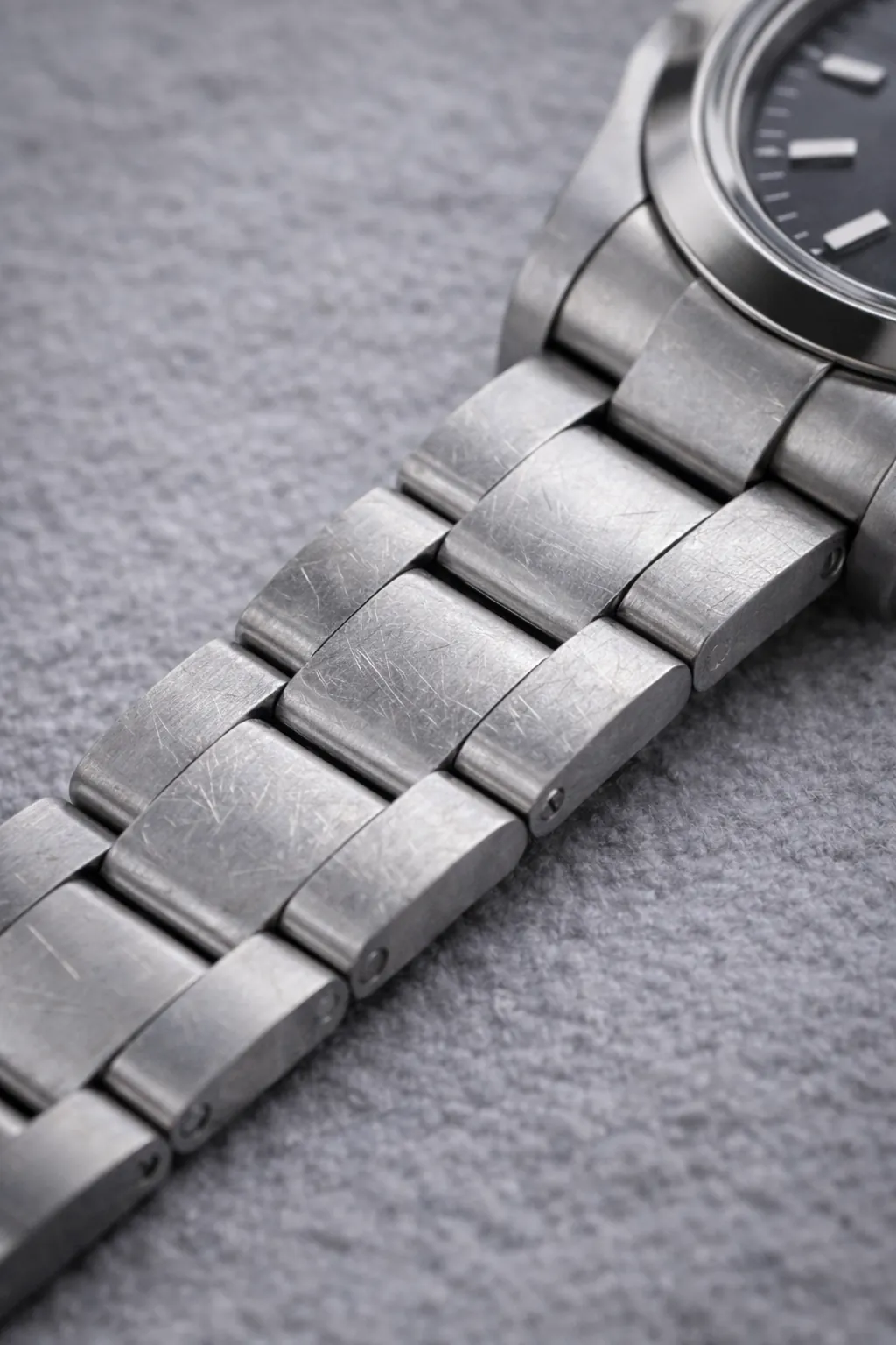 Close-up of stainless steel bracelet showing light scratches and natural wear over time